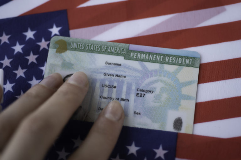A green card and United States flag